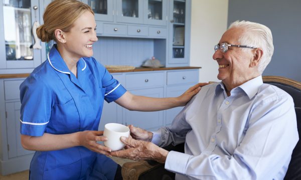 23593645-nurse-giving-senior-man-cup-of-tea-on-home-visit
