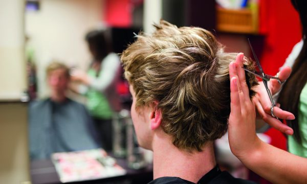 Blond-haired man having a haircut with scissors